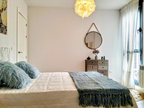 um quarto com uma cama grande e um espelho em apartamento La Coqueta em Santander