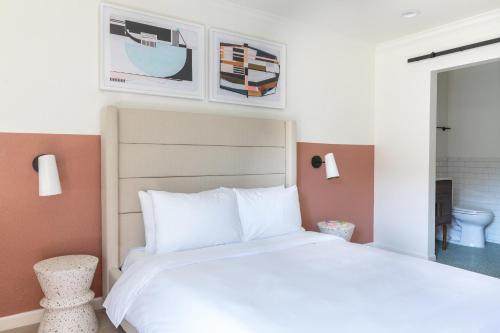 a bedroom with a white bed and pictures on the wall at Signature Inn Oakland in Oakland