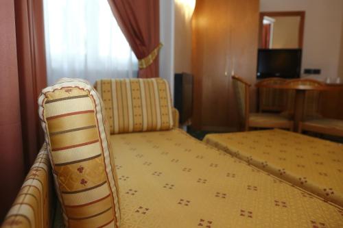 a hotel room with a bed and a chair at Hotel Estense in Modena