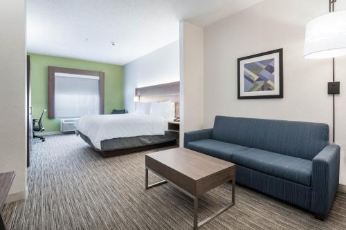 a hotel room with a bed and a couch at Holiday Inn Express Hotel & Suites Jasper by IHG in Jasper