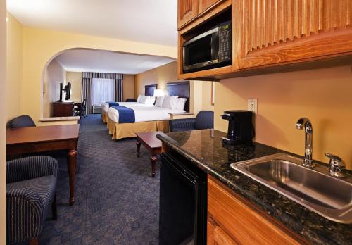 a hotel room with a bed and a kitchen with a sink at Holiday Inn Express & Suites, Corpus Christi NW, Calallen, an IHG Hotel in Corpus Christi
