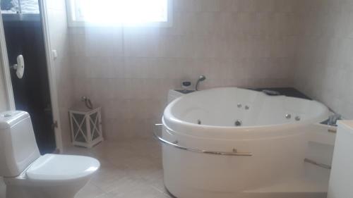 a bathroom with a white tub and a toilet at Gautefall- High-standard cozy cabin with indoors whirlpool-tub and sauna in Treungen