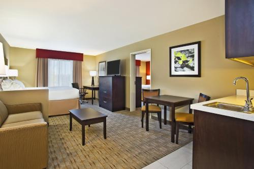 a hotel room with a bed and a kitchen at Holiday Inn Express & Suites Springfield by IHG in Springfield