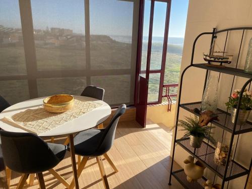 a table and chairs in a room with a view at Beachfront Apartment with Swimming Pool in Mindelo