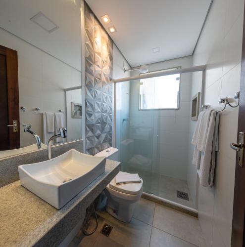 a bathroom with a sink and a toilet and a shower at Hotel Mount Everest in Nova Friburgo