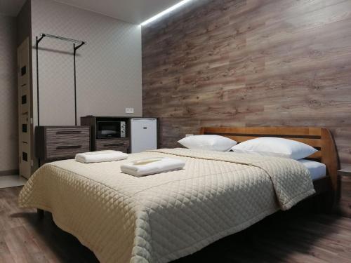 a bedroom with a large bed with a wooden wall at Solo Apartment Kamenskaya in Kyiv