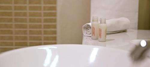 een badkamer met een witte wastafel en een spiegel bij Heraclea Hotel Residence in Policoro