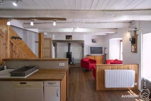 a room with a kitchen and a living room at Le Jassaguet in Murol