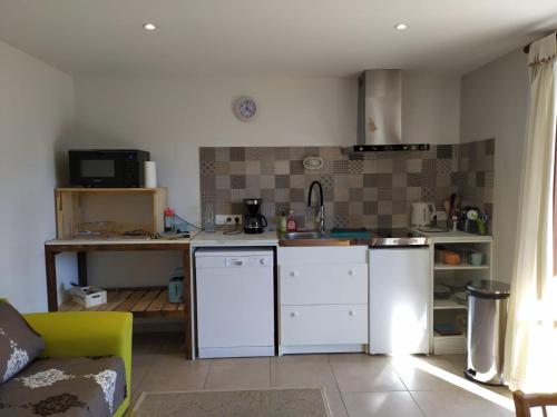 una cucina con elettrodomestici bianchi e un divano in camera di RAND'UBAYE a Barcelonnette