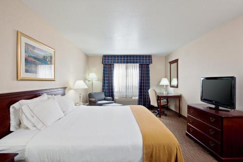 a hotel room with a bed and a flat screen tv at Holiday Inn Express & Suites Jackson by IHG in Jackson