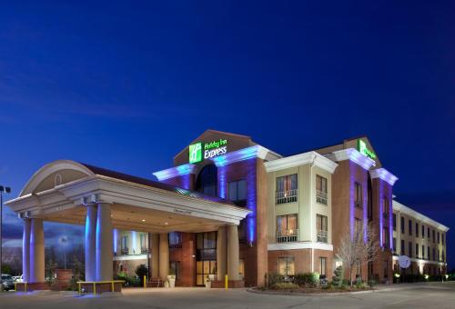 un edificio de hotel con un cartel en él por la noche en Holiday Inn Express Enid-Highway 412, an IHG Hotel, en Enid