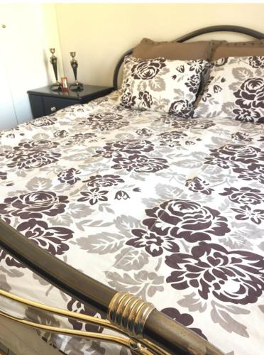 a bed with a black and white blanket and pillows at Respect to the Guest in Thessaloniki