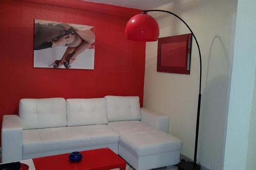 カップ・ダグドにあるCap d'Agde Naturist Héliopolis F61 vue merの白いソファと赤い壁のリビングルーム