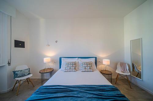 sypialnia z łóżkiem z 2 krzesłami i 2 lampami w obiekcie San Frediano Jewel we Florencji