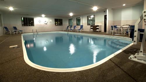 a large swimming pool in a building with chairs at Holiday Inn Express & Suites Evansville North, an IHG Hotel in Warrenton