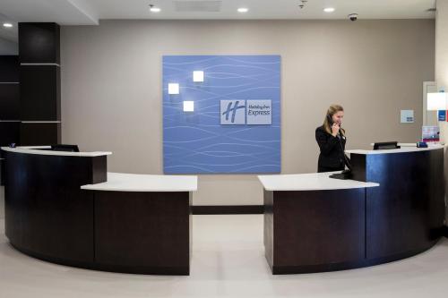 a woman talking on a cell phone in a lobby at Holiday Inn Express and Suites Edwardsville by IHG in Edwardsville