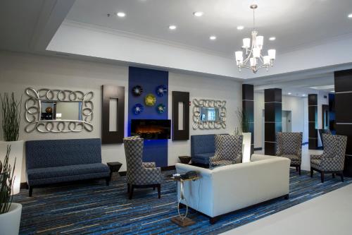 a lobby with chairs and a couch and a chandelier at Holiday Inn Express and Suites Edwardsville by IHG in Edwardsville