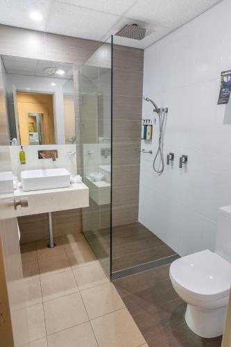 a bathroom with a toilet and a sink and a shower at Mercure Orange in Orange
