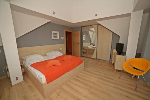 ein Schlafzimmer mit einem großen Bett und einem Stuhl in der Unterkunft Trzy Korony Drei Kronen 3 Balkone DELUXE 60m2 TOPVIEW in Świnoujście