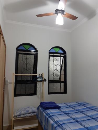 a bedroom with two stained glass windows and a bed at Pousada Acolhedora in Ribeirão Preto