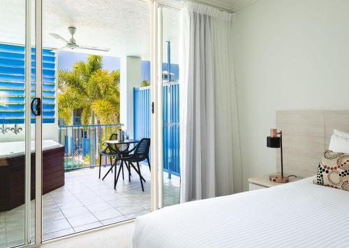 a bedroom with a bed and a view of the ocean at Silkari Lagoons Port Douglas in Port Douglas