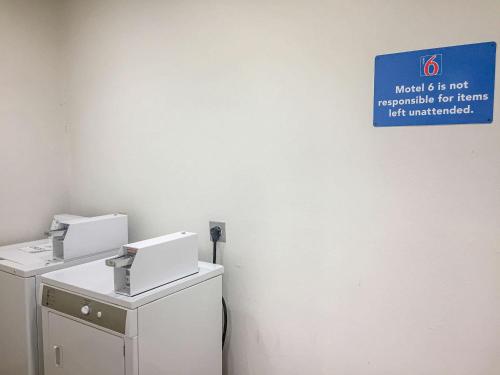 a sign on a wall next to two machines at Motel 6-Woodway, TX in Woodway