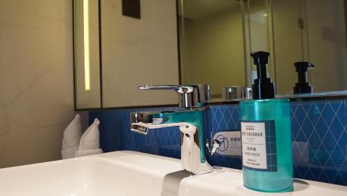 a bathroom sink with a toothbrush holder next to a faucet at Holiday Inn Express Shenzhen Dongmen by IHG in Shenzhen