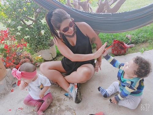a woman sitting on the ground with two children at Cabañas Guacari San Agustín huila in San Agustín