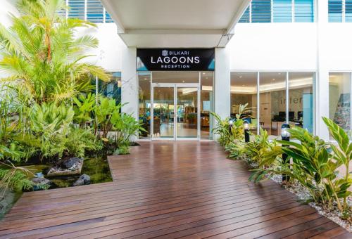 
a walkway leading to a large garden area at Silkari Lagoons Port Douglas in Port Douglas
