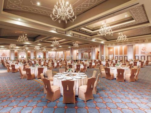 a banquet hall with tables and chairs and chandeliers at Rixos Premium Belek - The Land of Legends Access in Belek