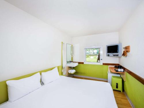 Habitación de hotel con cama y TV en ibis Budget Wentworthville en Wentworthville