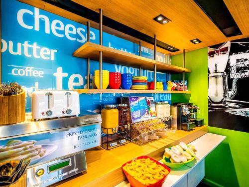 a coffee shop with a sign on the wall at ibis Budget Brisbane Airport in Brisbane