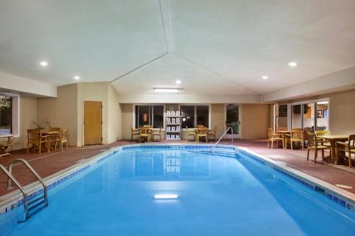 a large pool in a hotel with tables and chairs at Holiday Inn Express Hotel & Suites-Saint Joseph by IHG in Saint Joseph