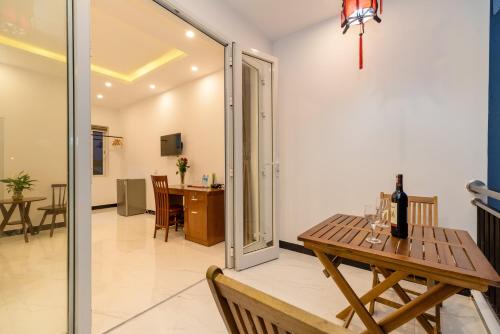 een eetkamer met een tafel met een fles wijn erop bij Horizon Homestay Hoi An in Hội An