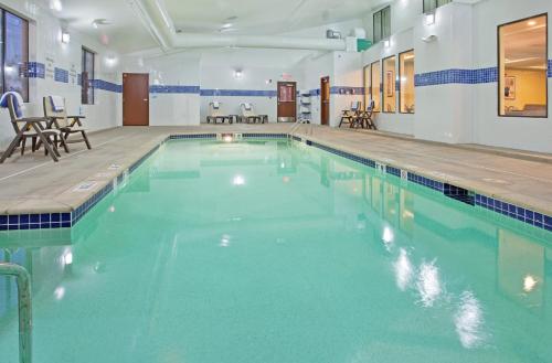 a large swimming pool with blue water in a building at Holiday Inn Express Hotel & Suites St. Charles by IHG in St. Charles