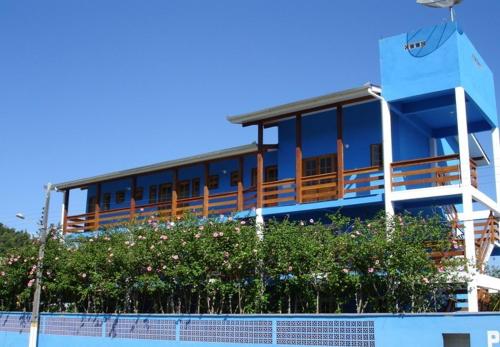 a blue building with a balcony and some flowers at Pousada Recanto Dom Arthur in Itapema