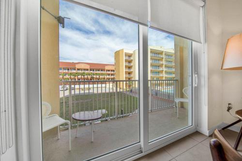 a room with a balcony with a view of a building at Peninsula Island Resort & Spa - Beachfront Property at South Padre Island in South Padre Island