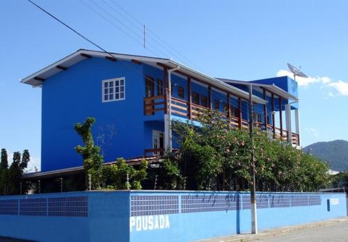 a blue building with a fence in front of it at Pousada Recanto Dom Arthur in Itapema
