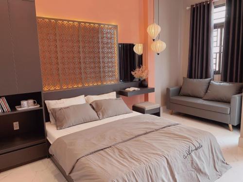 a bedroom with a large bed and a chair at 54 Homestay in Can Tho