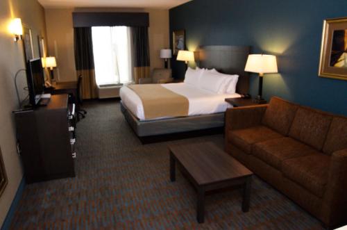 a hotel room with a bed and a couch at Holiday Inn Express Hotel & Suites Goldsboro - Base Area by IHG in Goldsboro