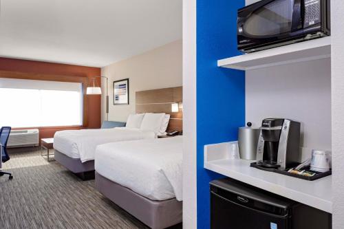 two pictures of a hotel room with a bed and a tv at Holiday Inn Express & Suites - Madison by IHG in Madison