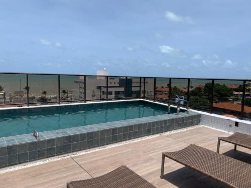 une piscine sur le toit d'un bâtiment dans l'établissement Flat aconchegante a 50 metros do mar, à João Pessoa