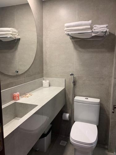 a bathroom with a toilet and a sink and a mirror at Flat UNO proximo ao mar in João Pessoa