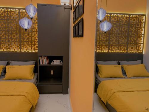 two beds in a room with yellow pillows and lights at 54 Homestay in Can Tho