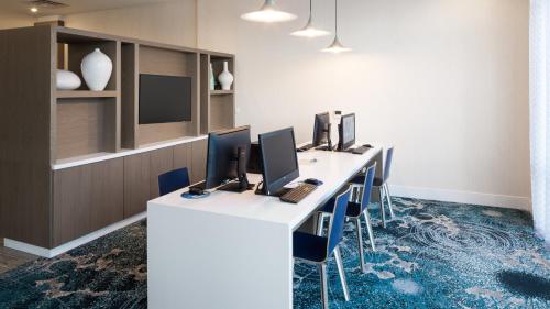 an office with a long desk with four computers on it at Holiday Inn Express & Suites Orlando At SeaWorld by IHG - With Free Shuttle Service to SeaWorld Parks in Orlando