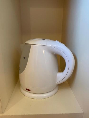 a white coffee maker in a corner of a room at Hotel Vega Takamatsu (Adult Only) in Takamatsu