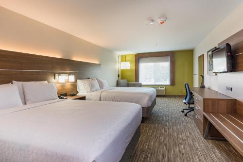 a hotel room with two beds and a flat screen tv at Holiday Inn Express Hotel & Suites Swansea by IHG in Swansea