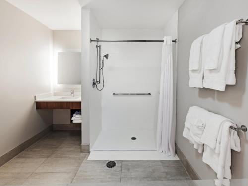 a white bathroom with a shower and a sink at Holiday Inn Express & Suites Tulsa West - Sand Springs by IHG in Sand Springs