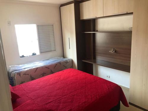 - une chambre avec un lit rouge et une fenêtre dans l'établissement apartamento próximo a praia da Enseada, à Guarujá