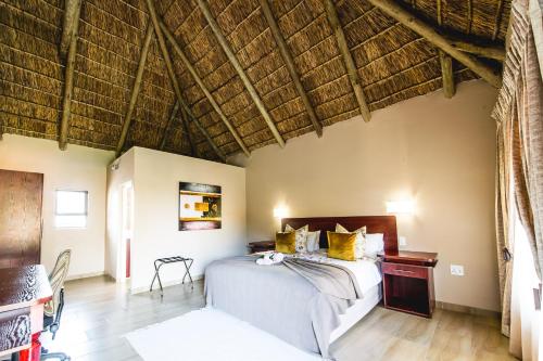 a bedroom with a bed and a wooden floor at Ritsako Game Lodge in Klipdrift